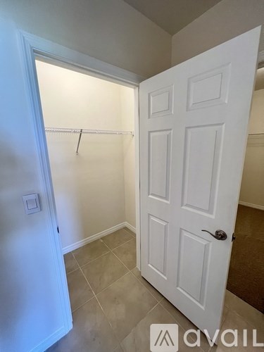 A white door is open in a room with a tiled floor.