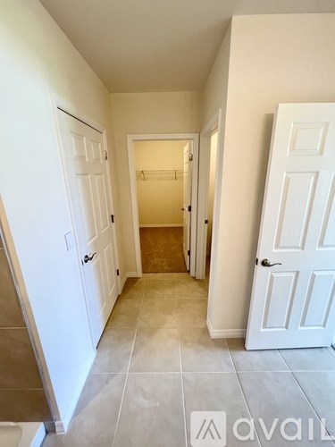 A hallway with two doors on either side and a third door at the end.