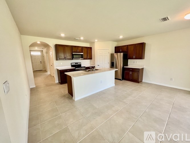 A spacious kitchen with a white island in the middle.