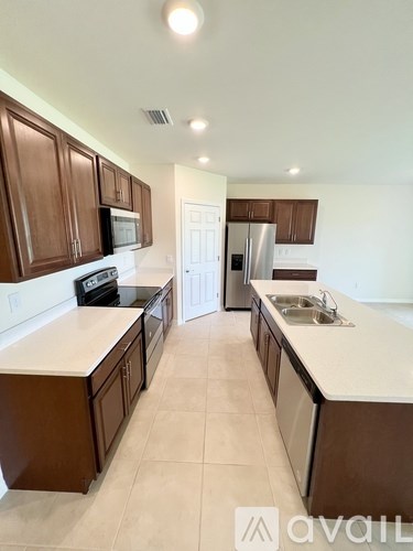 A kitchen with brown cabinets and a white counter.