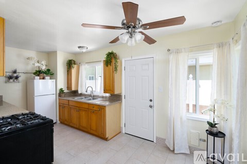 A kitchen with a black stove top oven and a white refrigerator.