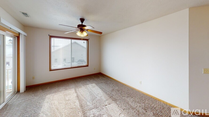 A room with a ceiling fan and a window.