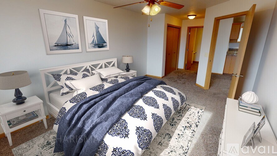 A bedroom with a bed covered in a blue and white patterned blanket.