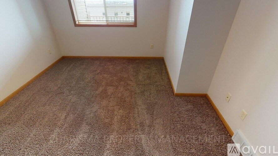 A room with a carpeted floor and a window.