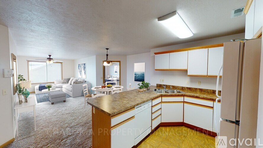 A kitchen with white cabinets and a brown countertop.