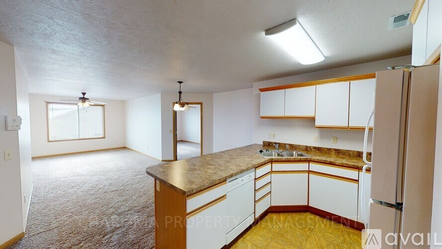 A kitchen with white cabinets and a brown countertop.
