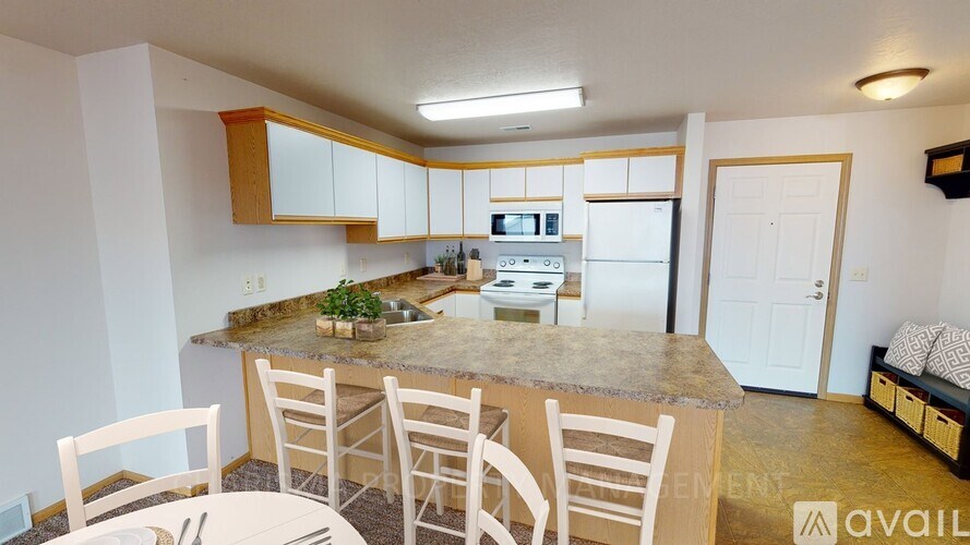 A kitchen with a table and chairs in front of it.