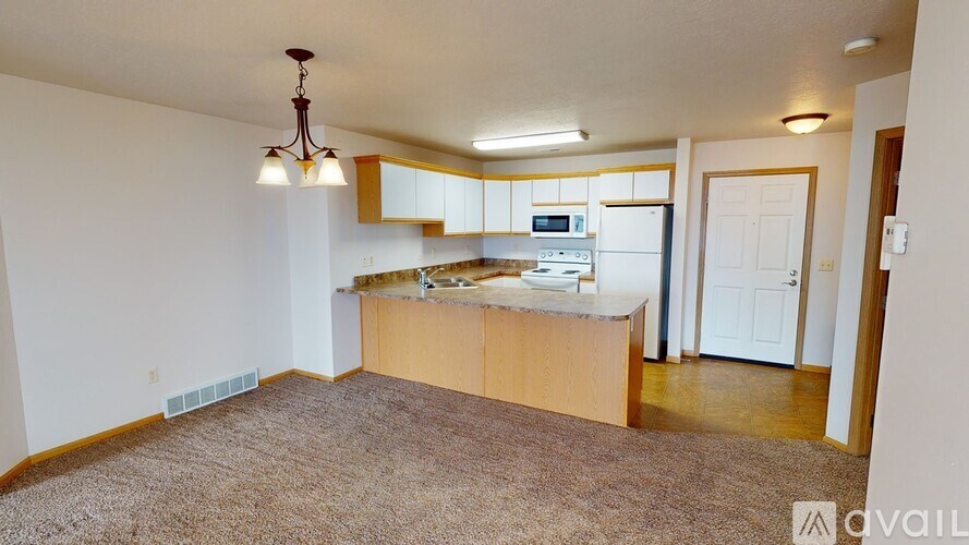 A kitchen area with a counter and cabinets is available for rent.