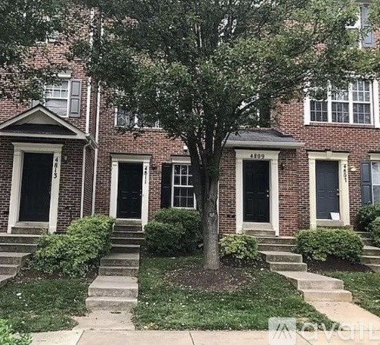 A tree in front of a brick building with the number 4109 on it.