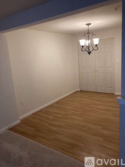 A room with a chandelier and a wooden floor.