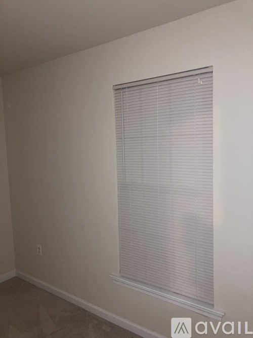A room with a window covered in blinds.