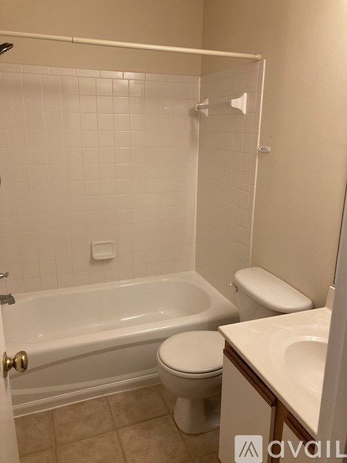 A white toilet sits next to a bathtub in a bathroom.