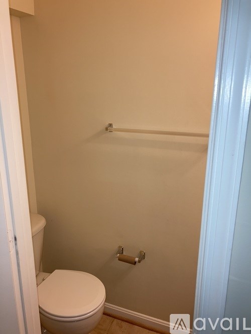 A white toilet in a small bathroom with a white door.