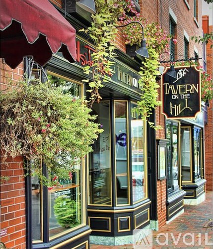 A sign on a building says "TAVERN ON THE HILL".