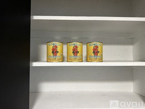 Three cans of canned tomatoes are lined up on a shelf.