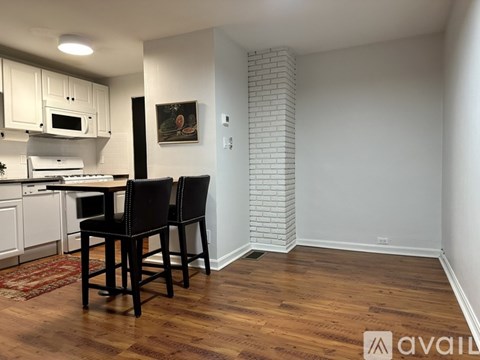 A kitchen with a dining table and chairs.