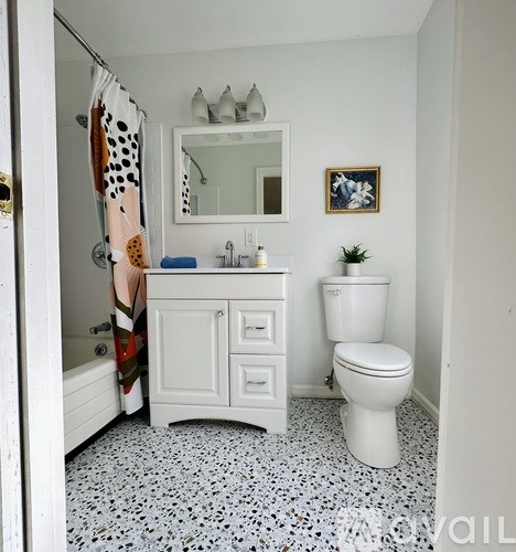 A bathroom with a toilet, sink, and a mirror.