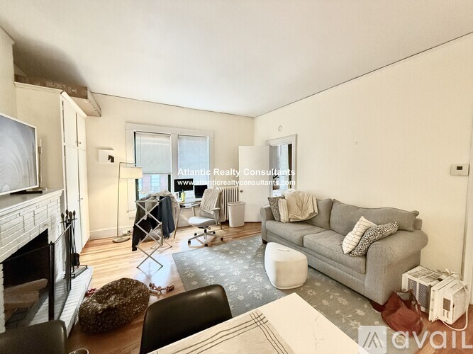 A living room with a white coffee table and a television on the wall.