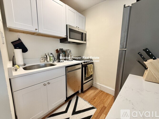 A small bathroom with a toilet, sink, and shower.