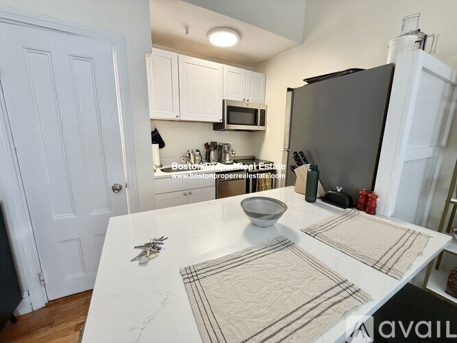 A large red brick building with a black car parked in front.