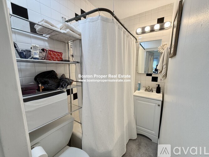 A small, white bathroom with a toilet, sink, and shower.