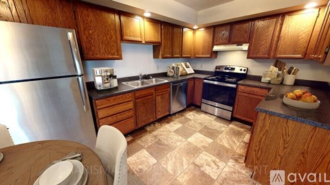 A kitchen with wooden cabinets and a tiled floor.