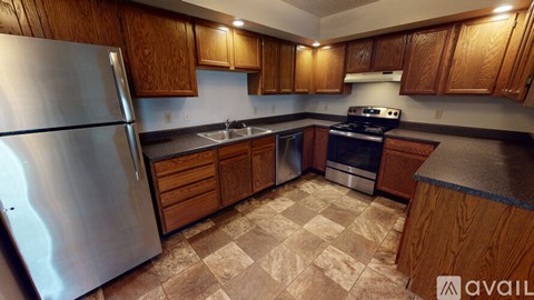 A kitchen with wooden cabinets and a checkered floor.