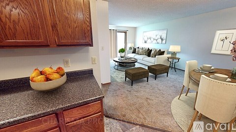 A kitchen with wooden cabinets and a countertop with a bowl of fruit on it.