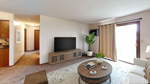 A living room with a flat screen TV and a coffee table.
