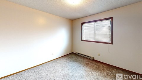 A room with a window and carpeted floor.