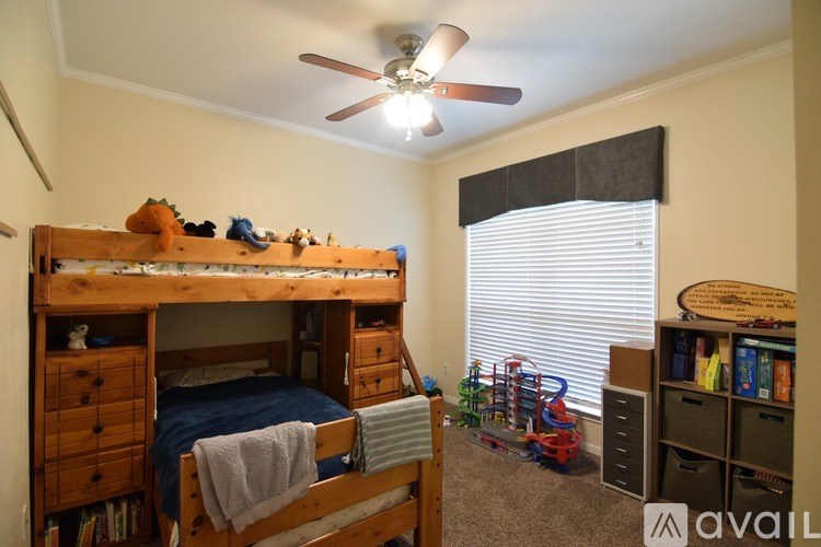 A room with a bunk bed and a ceiling fan.