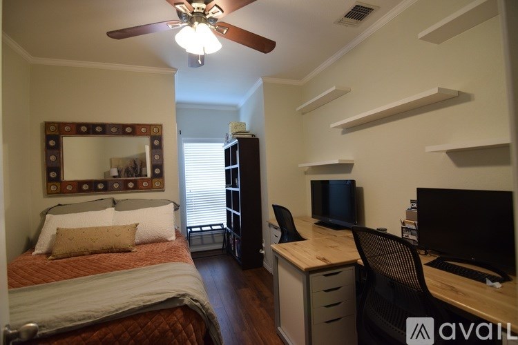 A bedroom with a bed, desk, and chair.