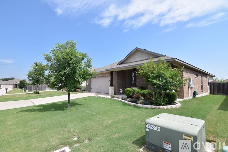 A house with a green lawn and a tree in front of it.
