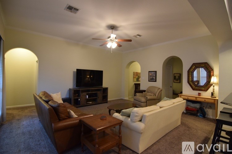 A living room with a brown leather couch and a white couch.