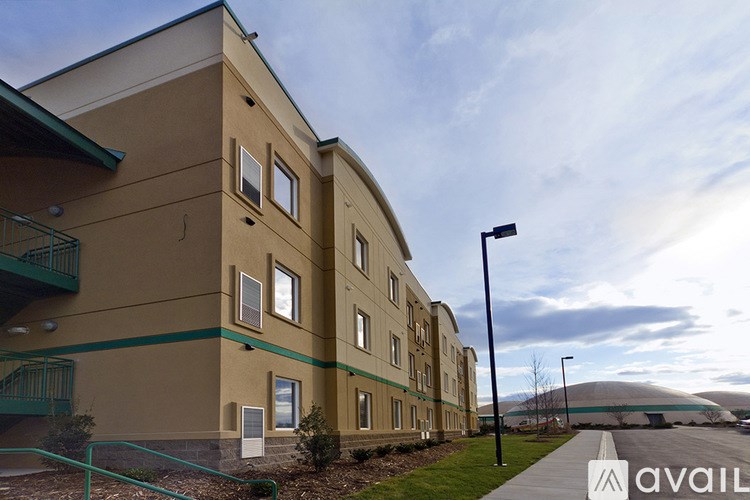 A building with a green railing and a sign that says "available" in front of it.