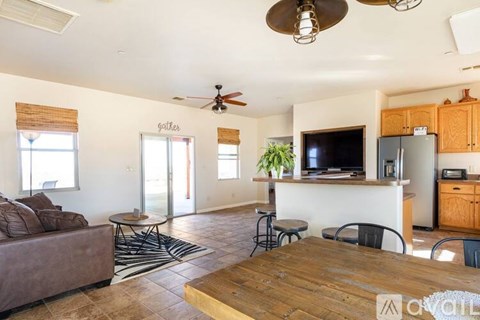 A living room with a brown couch and a wooden table.