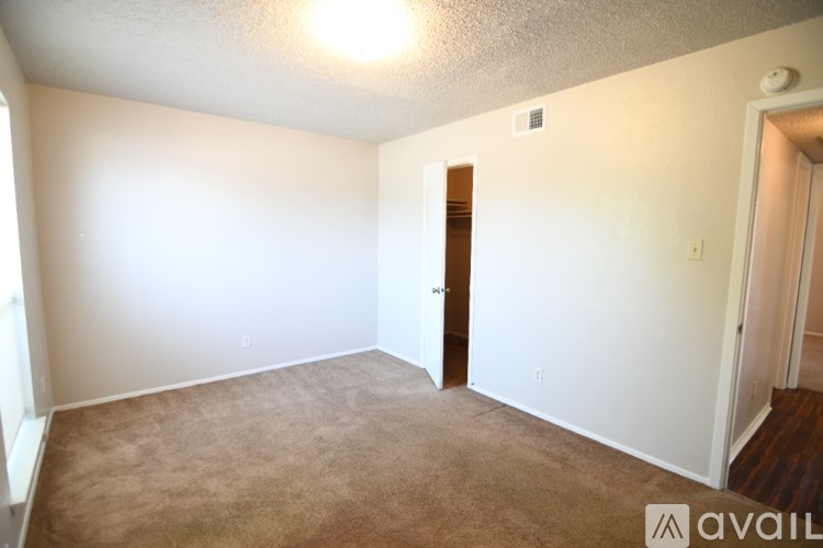 A room with a brown carpet and a door in the middle.
