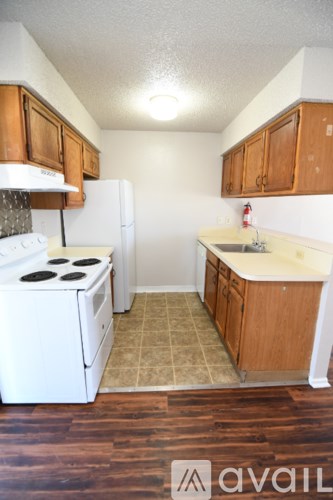 A kitchen with white appliances and wooden cabinets.