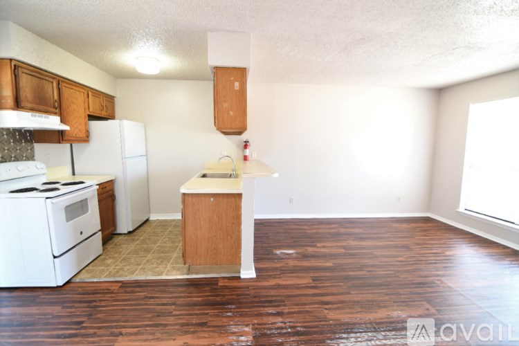 A kitchen with white appliances and wooden floors.