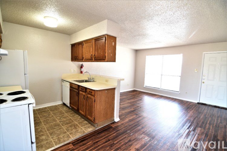 A kitchen with white appliances and wooden cabinets.