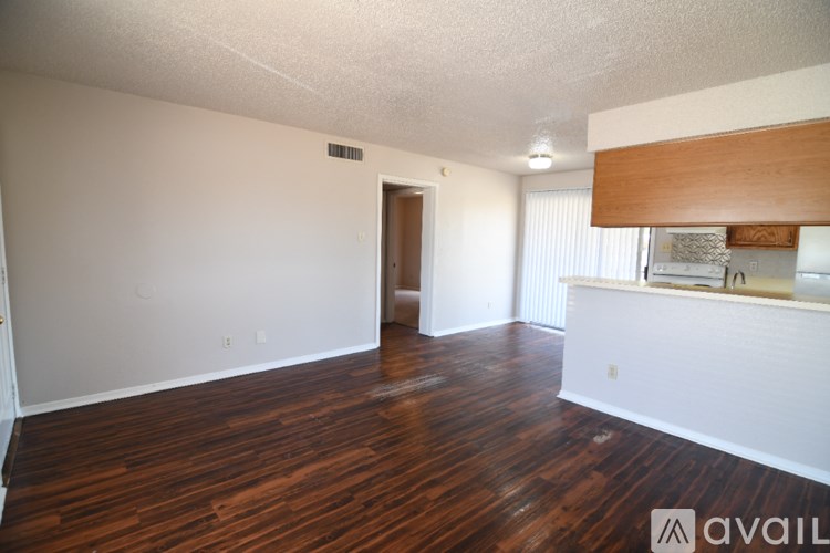 A room with wooden floors and white walls is available for rent.