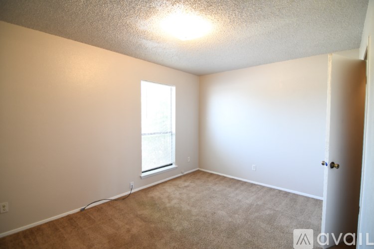 A room with a carpeted floor and a window.
