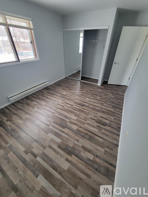 A room with wooden flooring and a window.