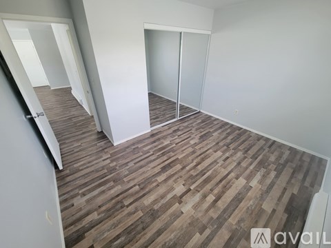 A room with wooden flooring and white walls.