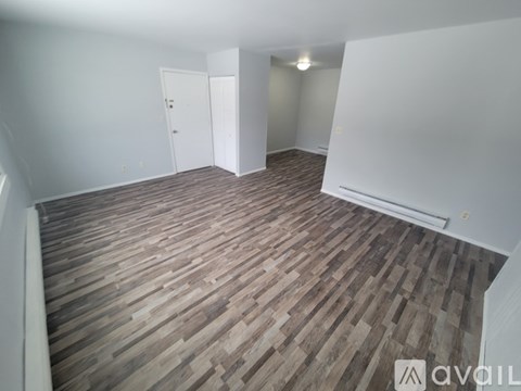 A room with wooden flooring and two doors.