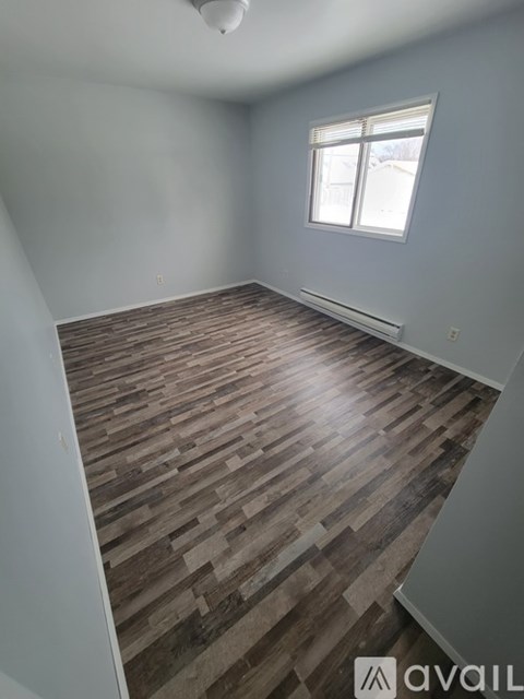 A room with wooden flooring and a window.