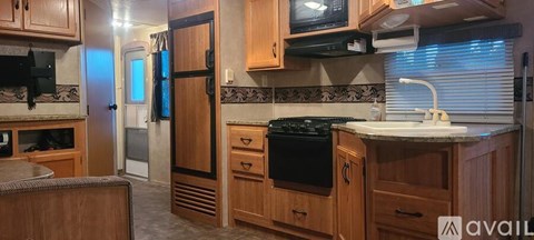 A kitchen with wooden cabinets and a black stove top oven.