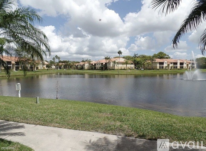 A lake in a park with a sign in front of it.