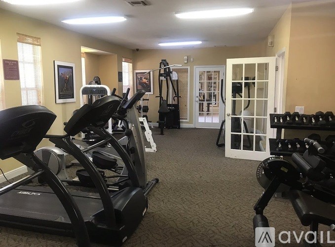 A gym with treadmills, weights, and exercise equipment.