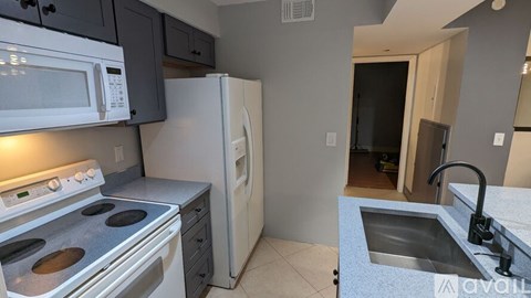A kitchen with a white refrigerator, white microwave, white oven, and a white stove top.
